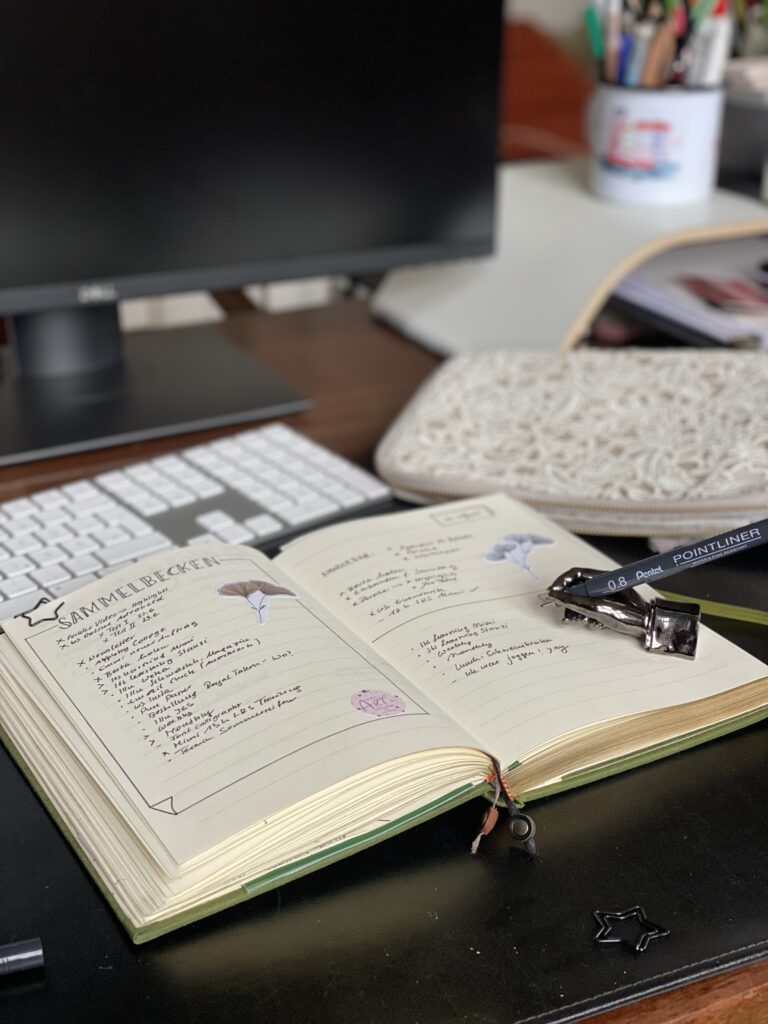 Geöffnetes Bullet Journal mit handgeschriebenem Sammelbecken — einer Brain-Dump-Liste mit Key Codes bei Mental Load und ADHS.
